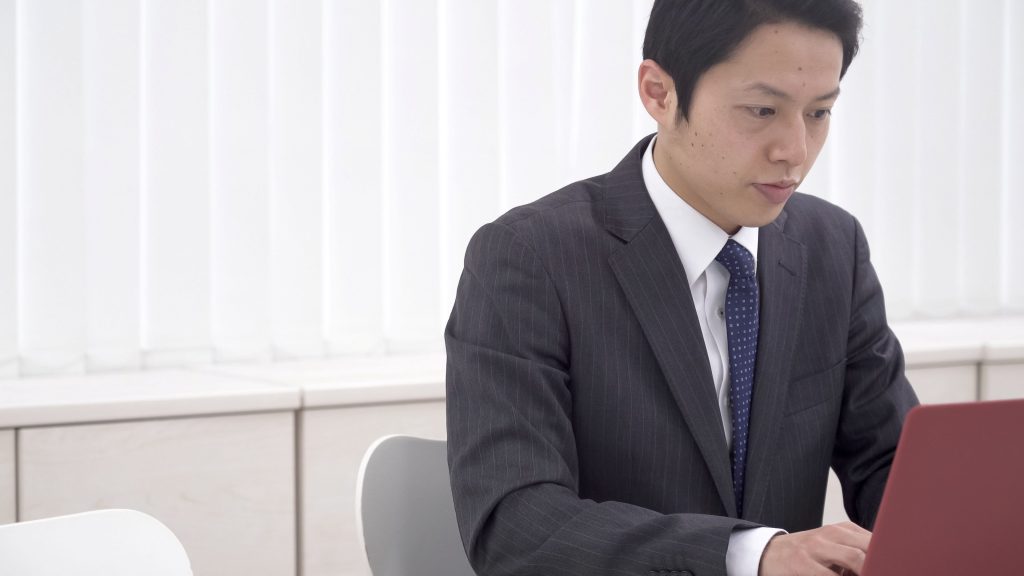 経営状況をパソコンで確認する中小企業事業主